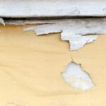 Yellow paint peeling off at concrete wall,texture background